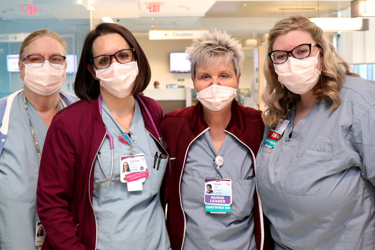 four Registered Nurses and co-workers in a clinical setting posing for a picture