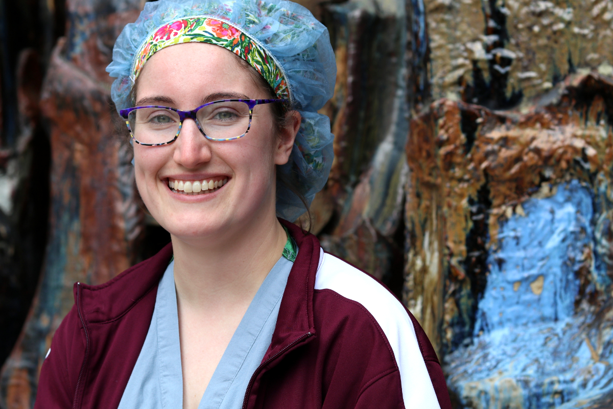 A Graduate Nurse wearing a colorful hairnet, smiling